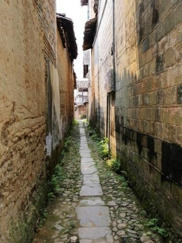 和平古鎮形成於明萬曆年間，因大戶人家為防土匪而倡建城堡式聚落，城牆與彎曲巷道隨之成形。近百條鵝卵石巷道隨形就勢，構成「九曲十三彎」的空間格局。和平古鎮雨聲在這樣的結構中被保存下來，雨落牆面與巷道之間，使防禦性的建築逐漸轉化為可被感受的日常節奏。